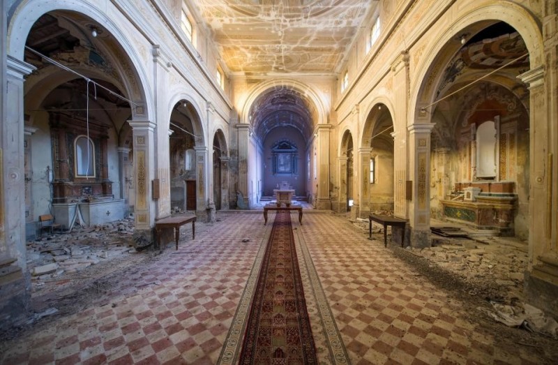 O impressionante tapete do corredor permanece nesta igreja na Itália, apesar da maioria dos móveis, incluindo os bancos, já terem sido esvaziados.