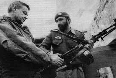 Zbigniew K. Brzezinski (à esq.), então Conselheiro de Segurança Nacional dos EUA no governo Jimmy Carter, com o então agente da CIA Tim (Osama Bin Laden) Osman discutem sobre armamentos a serem utilizados contra os soviéticos na Ásia Central